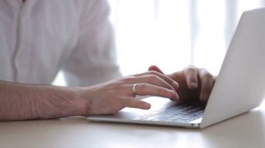 Klavyeye yazı yazan bir adam. Adam bilgisayarı kapatır ve pencereden sandalyeye bakar..