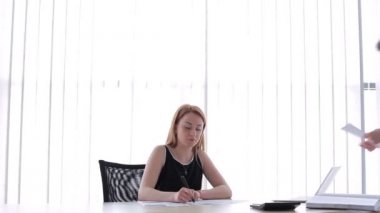 Pencerenin yanında oturan kız. Kız belgelere notlar yazmaya başladı. Genç adam kıza yaklaştı. Adam belgelerde bir hata gösteriyor. Kız bir kalem fırlattı ve hatayı inkar etmeye başladı..