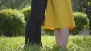 Aşık mutlu beyaz çift şefkatle sarılma ve yeşil bahar parkı nın arka planda gülümseyerek. Romantik vakit geçirmek açık havada. Yavaş çekim.