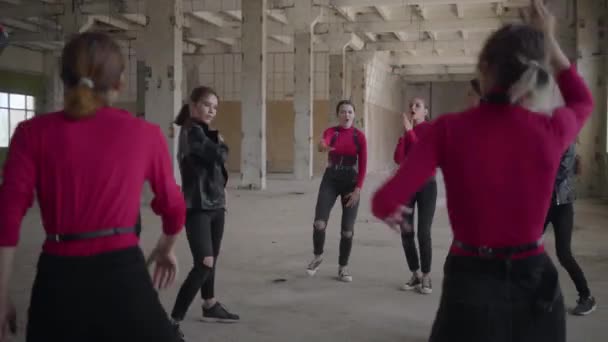 Bailarín de habilidades niñas y niños disfrutando de movimientos de hip hop realizando bailes de estilo libre juntos en un edificio abandonado. Caucásico banda hacer moderno freestyle danza en el interior . — Vídeos de Stock