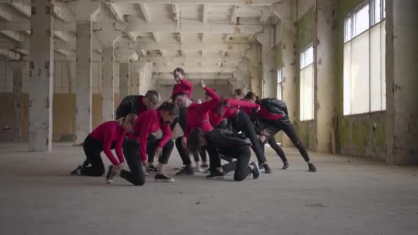 Bailarines profesionales niñas y niños disfrutando de movimientos de hip hop realizando bailes de estilo libre juntos en un edificio abandonado. Caucásico banda hacer moderno freestyle danza en el interior . — Vídeos de Stock