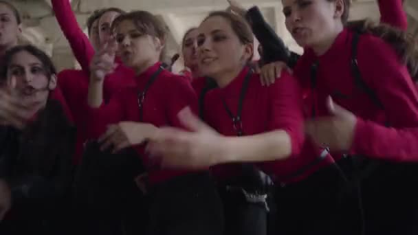 Una multitud de chicas jóvenes y chicos en el mismo escenario disfraces emocionalmente cantando una canción para el rodaje del video — Vídeos de Stock