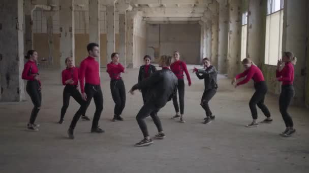 Bailarinas profesionales y chicos disfrutando de movimientos de hip hop realizando danza freestyle juntos en un edificio abandonado. La banda caucásica hace que el estilo libre moderno baile en interiores. Batalla de hip hop . — Vídeo de stock