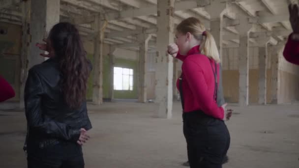 Danseurs professionnels filles et garçons appréciant les mouvements hip hop exécutant des danses freestyle ensemble dans un bâtiment abandonné. Groupe caucasien faire danse freestyle moderne à l'intérieur. Mouvement lent . — Video