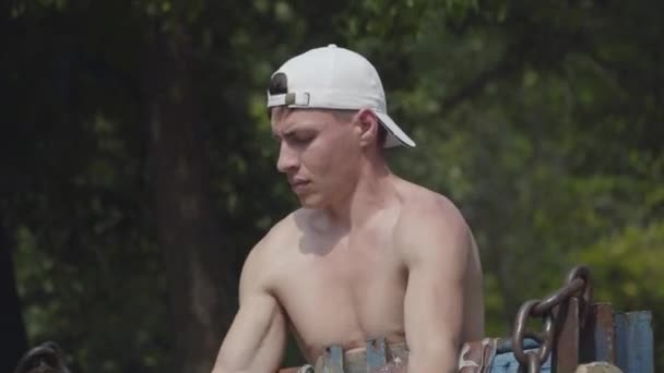 Athletic man raising the barbell in the park. Exercise for biceps. Close up portrait. Fitness concept. Healthy lifestyle — Stock Video