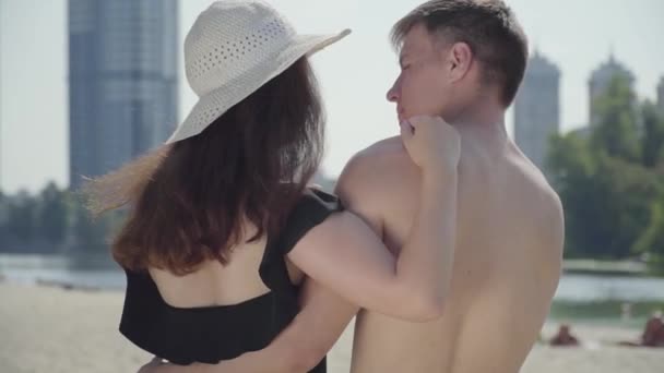 Back view of happy young couple hugging and looking at each other with love. Lovers enjoying weekends at hot sunny summer day. Summer leisure concept. Romantic date. Camera zooming — Stock Video