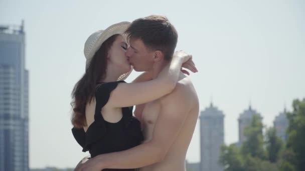 Happy young couple hugging looking in the eyes of each other with love and kissing. Lovers enjoying weekends at hot sunny summer day. Summer leisure concept. Romantic date — Stock Video