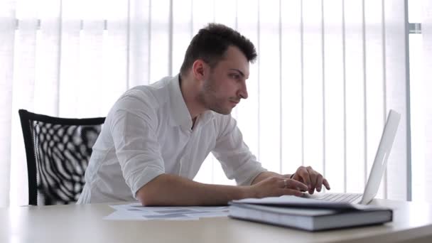 Jovem Sentado Cadeira Escritório Homem Começa Olhar Para Laptop Alternando — Vídeo de Stock