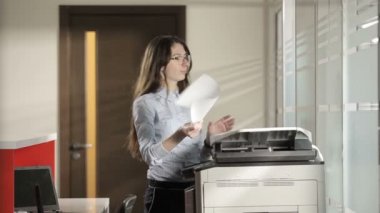 Kız bir belge basmak istiyor ama işe yaramıyor. Kız yardım etmesi için adamı arıyor. Adam belge basıyor. Kız kontrol ediyor. Adam ve kız kameraya bakıp gülümsüyor..