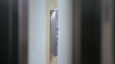Adamın eli asansör düğmesine basıyor. Bu eylem üç kez tekrarlanır..