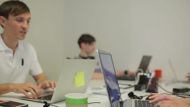 Joven Trabajando Portátil Oficina Sonríe Unas Palabras Hombre Escribiendo Portátil — Vídeos de Stock