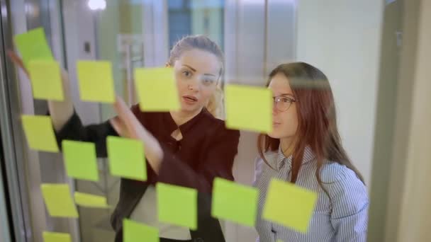 Dos Chicas Están Hablando Oficina Dos Chicas Pegando Pegatinas Vidrio — Vídeos de Stock