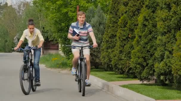 Estudiantes Ambos Sexos Montando Bicicletas Calle Con Libros Mano — Vídeos de Stock