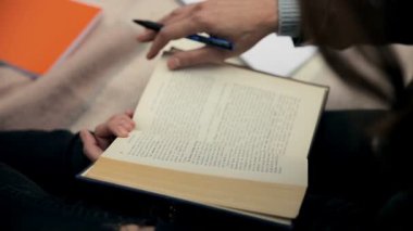 Closeup genç kız öğrenci oturma ve kitap okuma açık havada, Öğrenci egzersiz kitabı ve yazma notlar yapma 