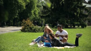 yeşil çim çim öğrenme hometask üzerinde battaniye üzerinde yatan üç öğrencinin video 