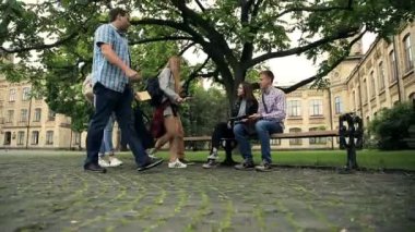 kampüs parkında bankta oturan ve sınıf arkadaşlarını bekleyen güzel çiftin videosu