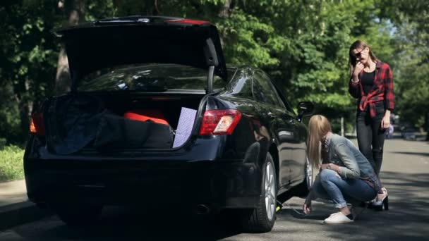 Jovens Mulheres Encantadoras Lado Carro Quebrado Com Tronco Aberto Tentando — Vídeo de Stock