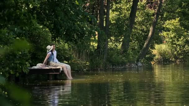 Couple Sitting Bridge River Bank Dipping Feet Water Girl Guy — Stock Video