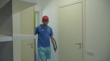 Otel odasına roketlerle giren genç spor çifti. Gül elbiseli kız ve mavi spor giyen adam giyer. Aktif eğlence ve yaşam tarzı. Spor ve rekreasyon.