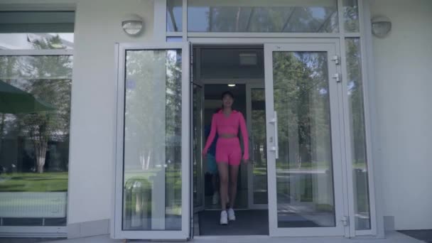 Atletisk ungt par i sport outfit ut ur hotellet för en promenad. Aktiv livsstil. Sport och fritid. — Stockvideo