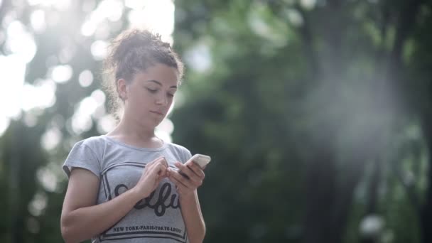 Chica Rizada Sostiene Teléfono Inteligente Las Manos Mujer Corre Parque — Vídeos de Stock