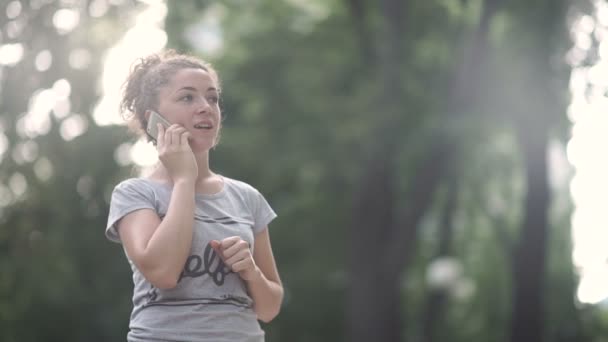 Vidéo Fille Bouclée Parler Sur Smartphone Tout Tenant Dans Parc — Video