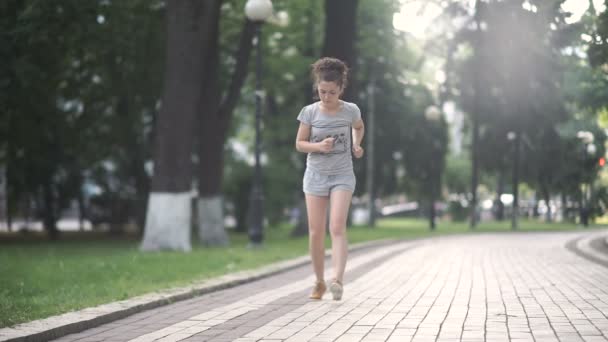 公園の道路を走るスポーティな女性のビデオ — ストック動画