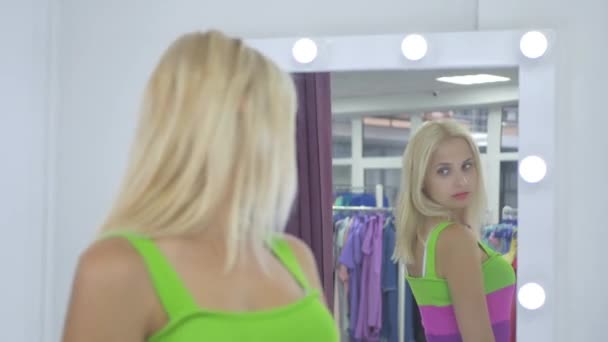 Blond Kvinna Tittar Spegel Omklädningsrum Showroom Video — Stockvideo