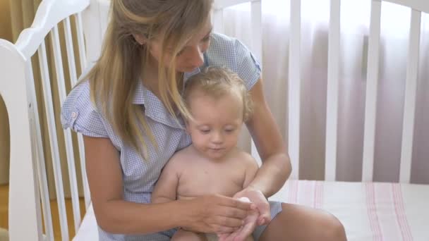 彼女の手にビタミンをこぼす女性 ママと赤ちゃんの手はビタミンを取る 女の子はビタミンを口の中に置く — ストック動画