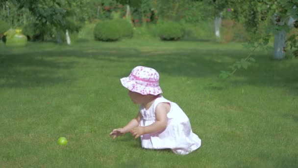 Baby Crawling Grass Apple Girl Picks Apple Brings Her Mouth — Stock Video