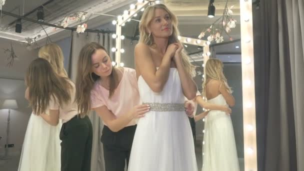Bruden Tittar Spegeln Assistenten Hjälper Flickan Och Korrigerar Bältet Bröllopsklänningen — Stockvideo