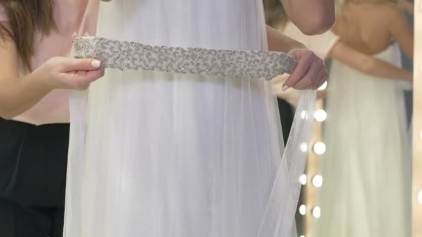 Close Camera Focuses White Wedding Dress Bridesmaid Carefully Puts Belt — ストック動画