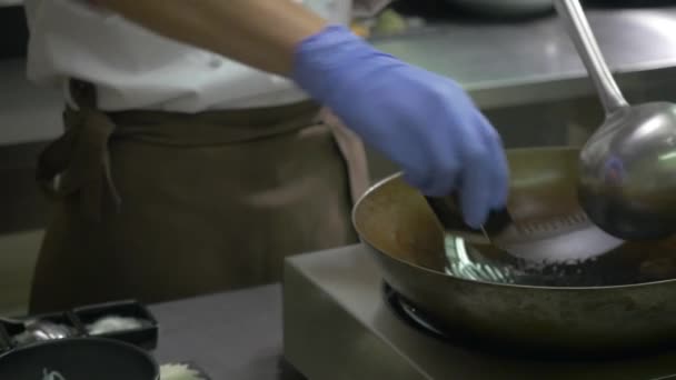 클로즈업 요리사는 기름을 뜨거운 남비에 붓습니다 요리사의 네모난 그릇에서 고기를 — 비디오