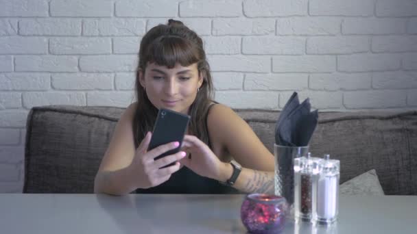 Mooie Brunette Zit Tafel Bank Het Restaurant Gebruikt Haar Gadget — Stockvideo