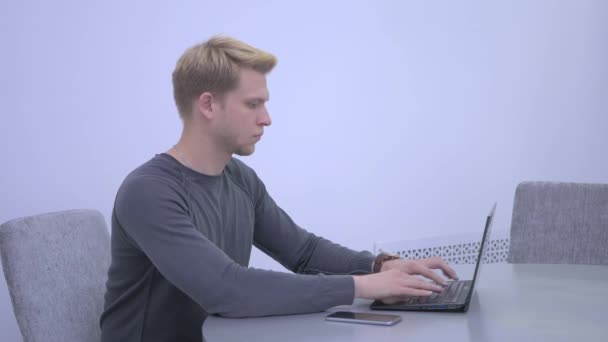 Hombre Atractivo Camisa Gris Sentado Silla Mesa Escribiendo Computadora Portátil — Vídeo de stock