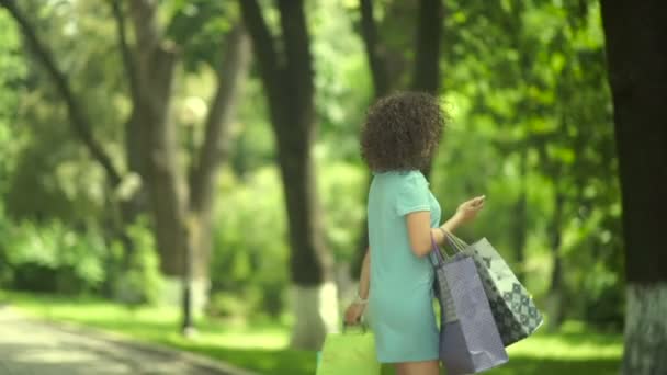 Σγουρή Γυναίκα Περπατά Τσάντες Ψώνια Στο Πάρκο — Αρχείο Βίντεο