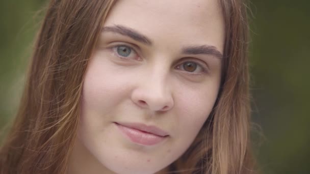 Close-up portrait of pretty carefree young woman with different colored eyes looking at camera indoors. Happy caucasian woman greets new day. Leisure, day off at home. Real people series. — Stock Video