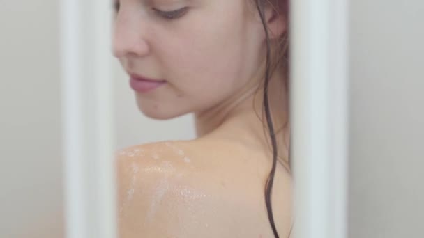 Мила біла жінка приймає душ вдома або в готелі. Красива дівчина миє і насолоджується собою під душем — стокове відео