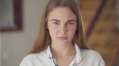 Kamera kapalı bakarak farklı renkli gözleri ile kendine güvenen kaygısız sevimli kadın Portresi. Baş ağrısı olan genç kız elleriyle başını ovuşturuyor. Migren, hasta baş ağrısı. Gerçek insanlar serisi.