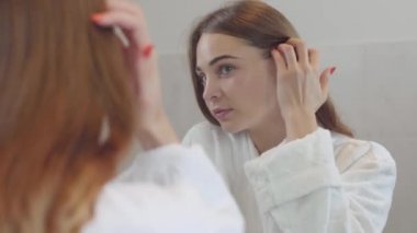 Pürüzsüz sağlıklı bir cilde sahip genç kadının yakın çekim güzellik portresi, o hafifçe parmaklarıile yüzüne dokunur. Farklı renkli gözleri ile sevimli kız. Cilt bakımı ve güzellik konsepti. Gerçek insanlar serisi.