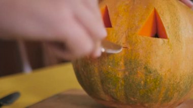 Cadılar Bayramı partisinde mutfak masasında balkabağı hazırlayan kadının videosu. 