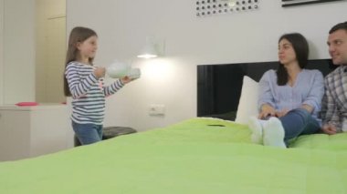 Küçük kız çaydanlığı ve fincanı alır ve ailesine getirir. Kız anneye bir fincan verir ve bir yatağa oturmaya çalışır. Kız babaya çaydanlık verir ve kadının yanına oturur. Sevimli kız ailesine sarılıyor ve gülümsüyor..