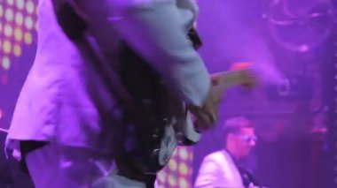 Gitarist konserde elektronik gitarla çalıyor. Gitarlı adam sahnede duruyor ve bir müzik çalıyor. Müzisyen rock konserinde gitar çalar. Kaya gitaristinin etrafında aydınlanma yanıp sönüyor.