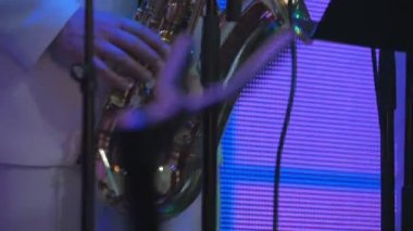 Konserde saksafonda çalan saksafoncu. Saksafonlu adam sahnede duruyor ve bir müzik çalıyor. Müzisyen konserde saksafon çalar. Aydınlanma saksafoncunun etrafında yanıp sönüyor.
