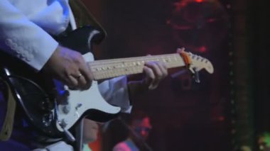 Gitarist konserde elektronik gitarla çalıyor. Gitarlı adam sahnede duruyor ve bir müzik çalıyor. Müzisyen rock konserinde gitar çalar. Kaya gitaristinin etrafında aydınlanma yanıp sönüyor.