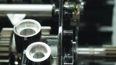 Yakın plan. Kamera sağdan sola hareket ediyor. Detaylı olarak motorsikletin metal transmisyonu. Kamera vites kutusunun çelik elementlerine odaklanır.