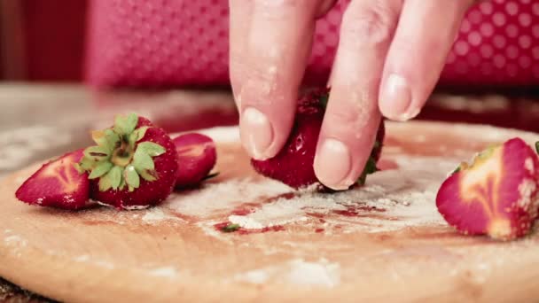 这个人正在厨房做饭 厨师在木板上把新鲜的草莓切成小块 照相机的镜头是一只雄性手在桌边切浆果 — 图库视频影像