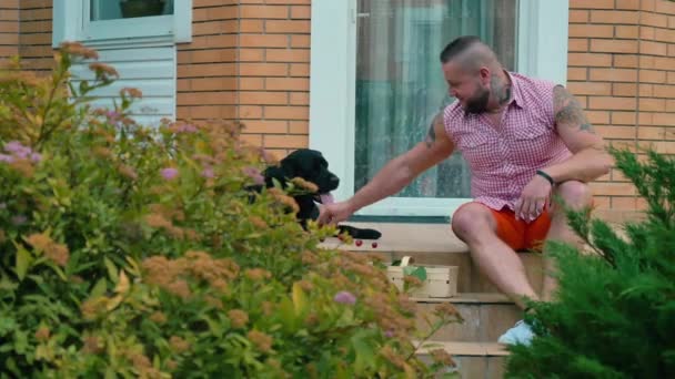 Jeune Homme Est Assis Sur Porche Extérieur Chien Noir Trouve — Video