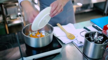 Aşçı soğan ve havucu tabaktan sıcak yağlı tencereye koydu..