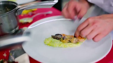 Tabakta püre, karides ve midye var. Aşçı karidesleri tabağa koydu..